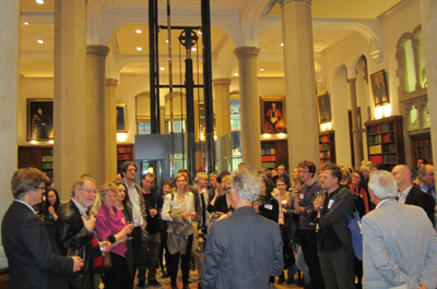 A group of people standing in a vague circle listening to someone speaker